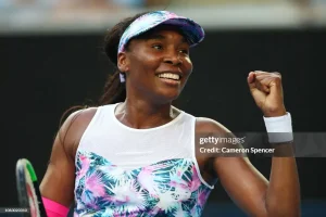 venus williams smiling in the game court with her fist closed looking like she scored